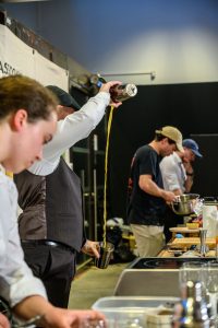 Un bartender réalise une technique de versé en hauteur lors du concours Battle Tour des Terroirs